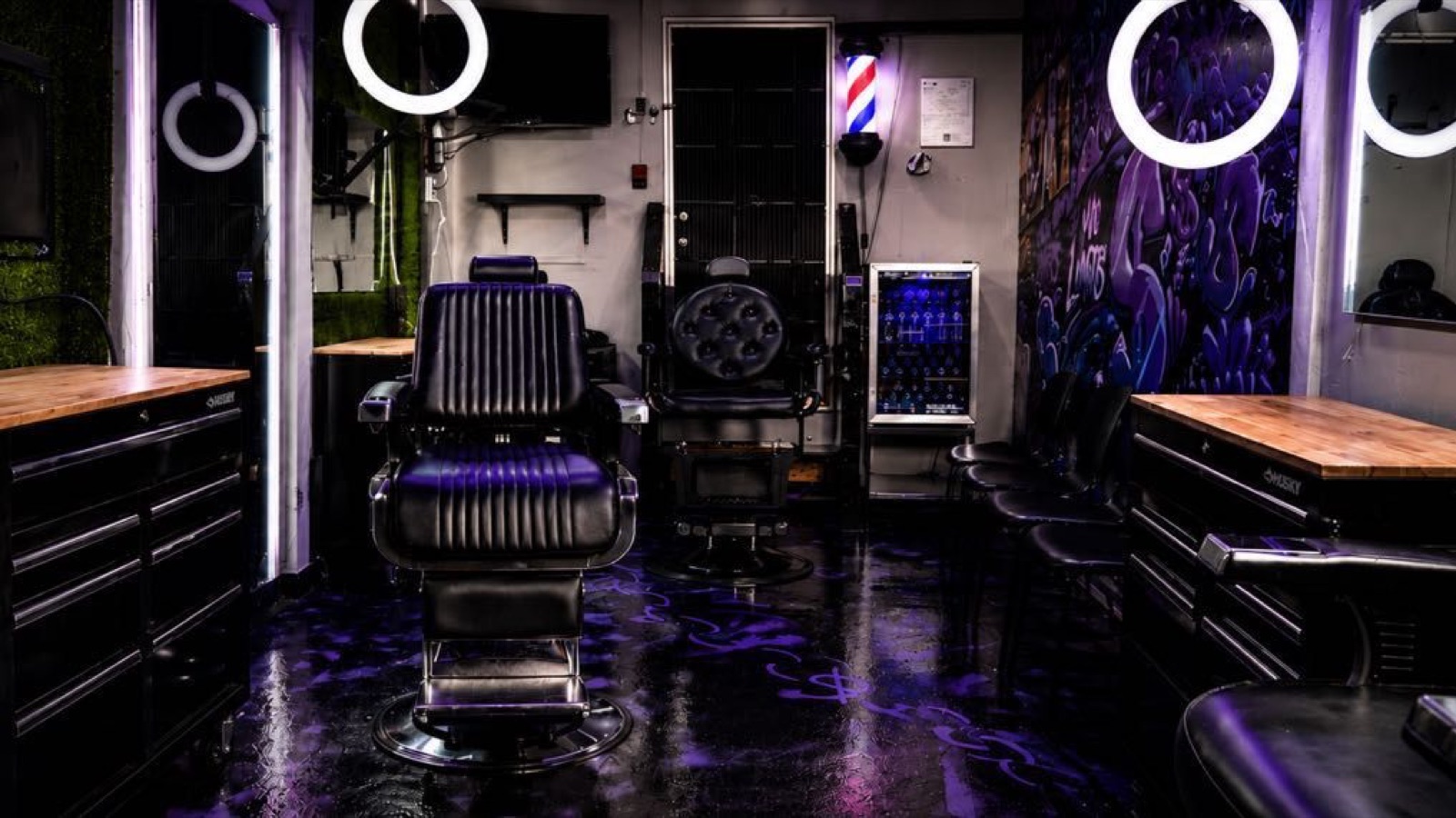 Inside No Limits Barbershop, purple-lit chairs and graffiti wall